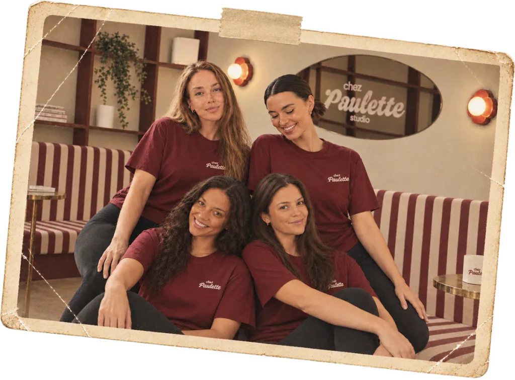 Les coachs de Chez Paulette en t-shirt bordeaux, sur la banquette rayée du studio de Pilates